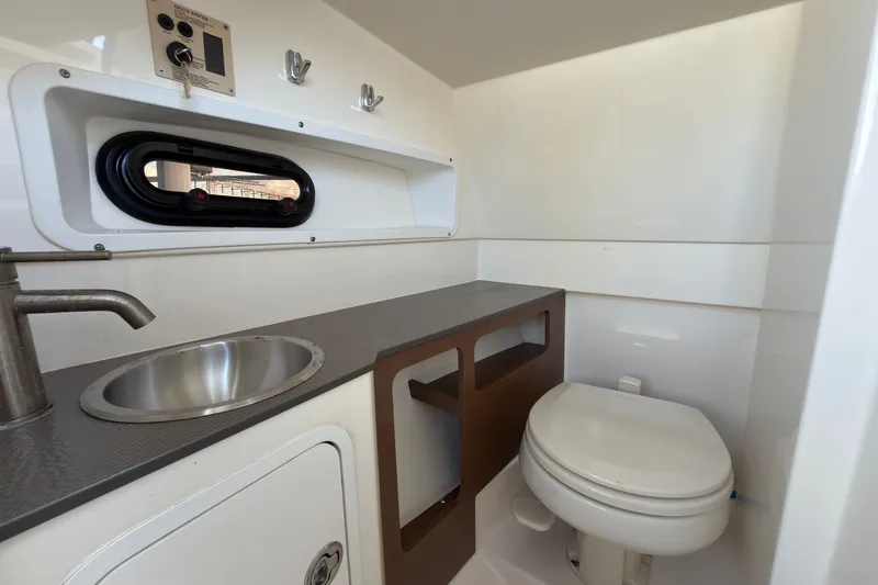 Slide: The Image of Interior of 2021 Sea Ray SDX 270 boat bathroom with sink and toilet. - 10