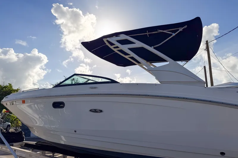 Slide: The Image of 2021 Sea Ray SDX 270 boat with canopy, parked under a bright sky. - 1