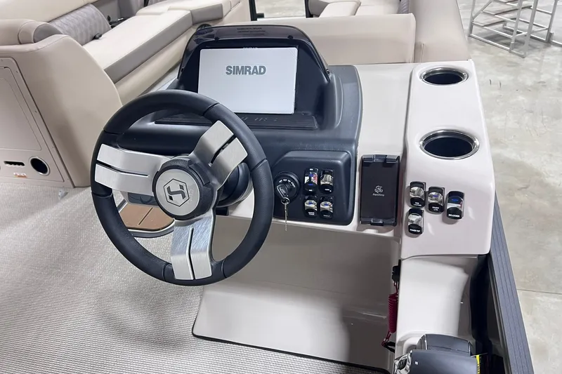 Slide: The Image of 2026 Harris Cruiser 250 dashboard with steering wheel and Simrad display. - 13