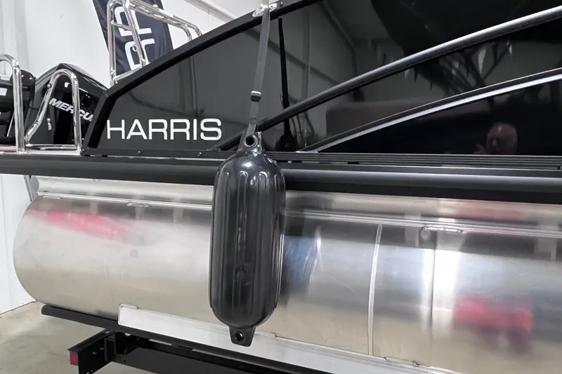 Slide: The Image of 2026 Harris Cruiser 250 pontoon boat with black fender and sleek design. - 39