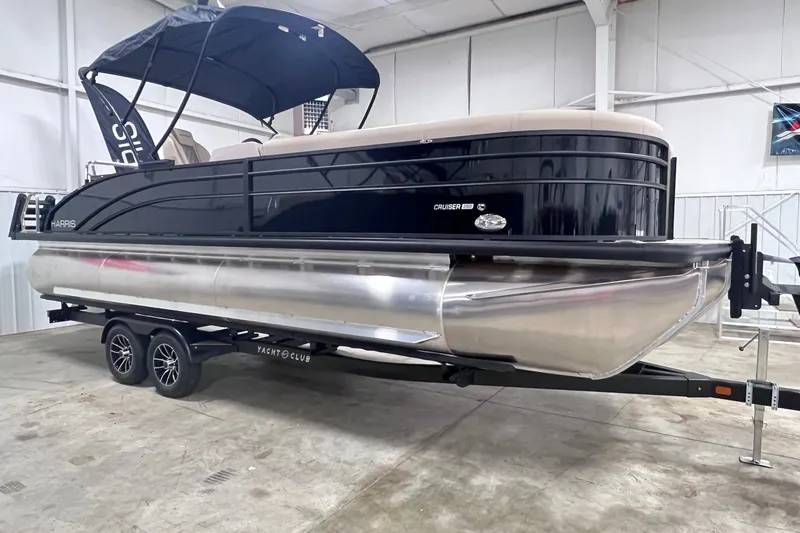 Slide: The Image of 2026 Harris Cruiser 250 pontoon boat on trailer in indoor storage facility. - 2