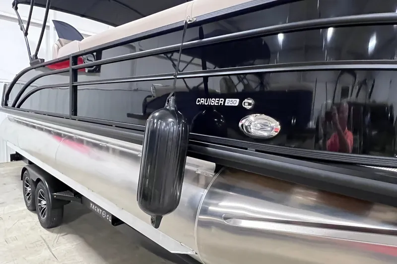 Slide: The Image of 2026 Harris Cruiser 250 pontoon boat with sleek black exterior and protective fender. - 37