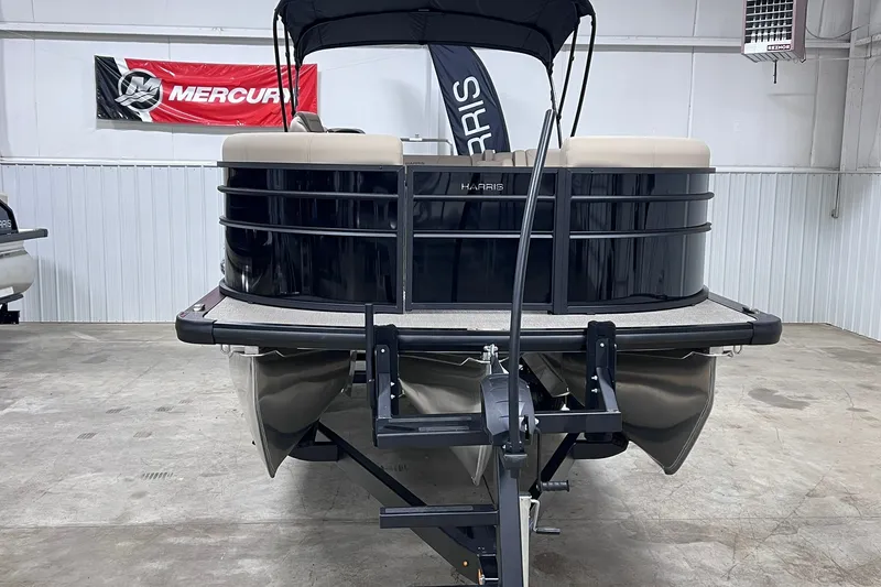 Slide: The Image of 2026 Harris Cruiser 250 pontoon boat in showroom, featuring sleek black design. - 4