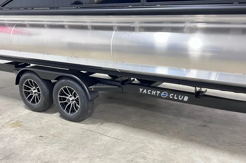 Slide: The Image of 2026 Harris Cruiser 250 pontoon boat on Yacht Club trailer, featuring sleek design and dual axles. - 44