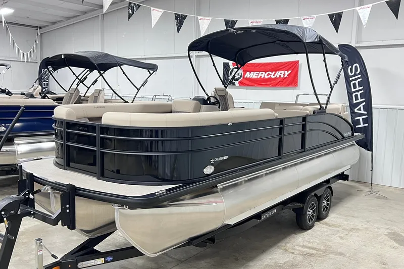 The Image of 2026 Harris Cruiser 250 pontoon boat displayed indoors on a trailer. - 0