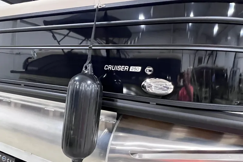 Slide: The Image of 2026 Harris Cruiser 250 boat with sleek black exterior and protective fender. - 38