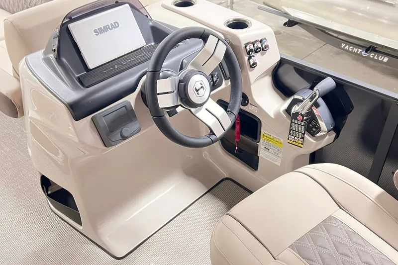 Slide: The Image of 2026 Harris Cruiser 250 boat dashboard with steering wheel and Simrad display. - 15