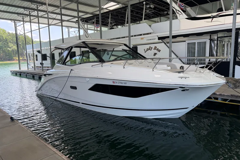 Slide: The Image of A 2025 Sea Ray Sundancer 320 docked in a covered slip. It features a sleek, modern design. - 29