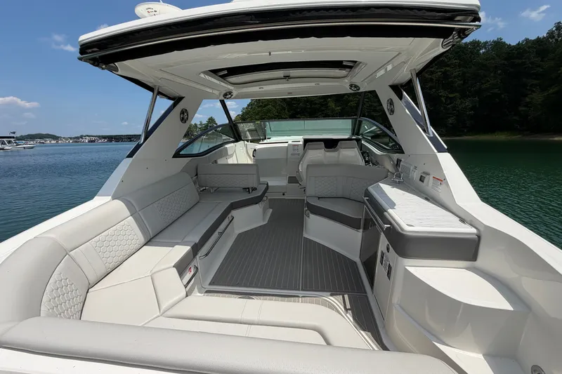 Slide: The Image of 2025 Sea Ray Sundancer 320 interior, featuring luxurious seating and sleek design on a serene lake. - 25