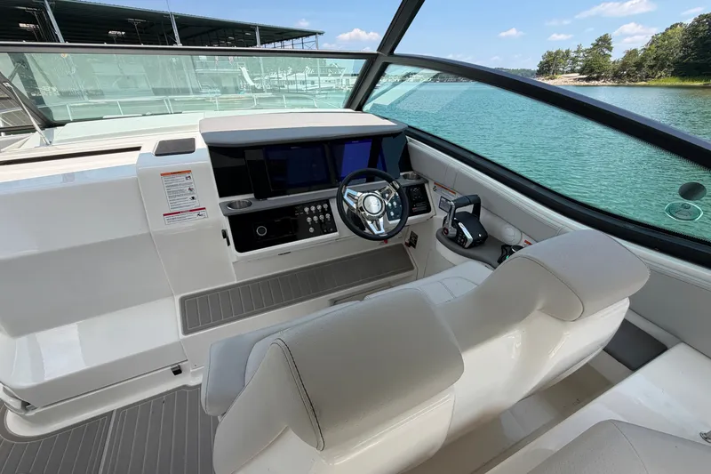 Slide: The Image of 2025 Sea Ray Sundancer 320 helm with modern controls and scenic water view. - 17