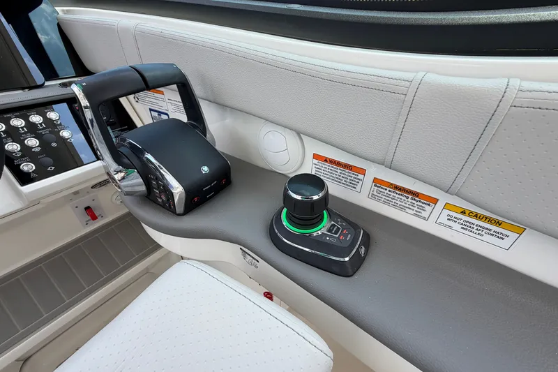 Slide: The Image of 2025 Sea Ray Sundancer 320 helm controls with joystick and throttle, featuring modern design. - 19