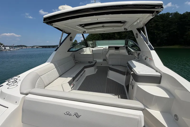 Slide: The Image of 2025 Sea Ray Sundancer 320 boat interior with luxurious seating and sleek design on a sunny day. - 26