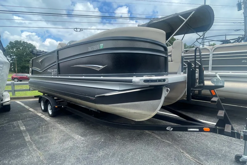 The Image of 2023 Premier SOLARIS 230 RL PTX pontoon boat on trailer, parked outdoors. - 2