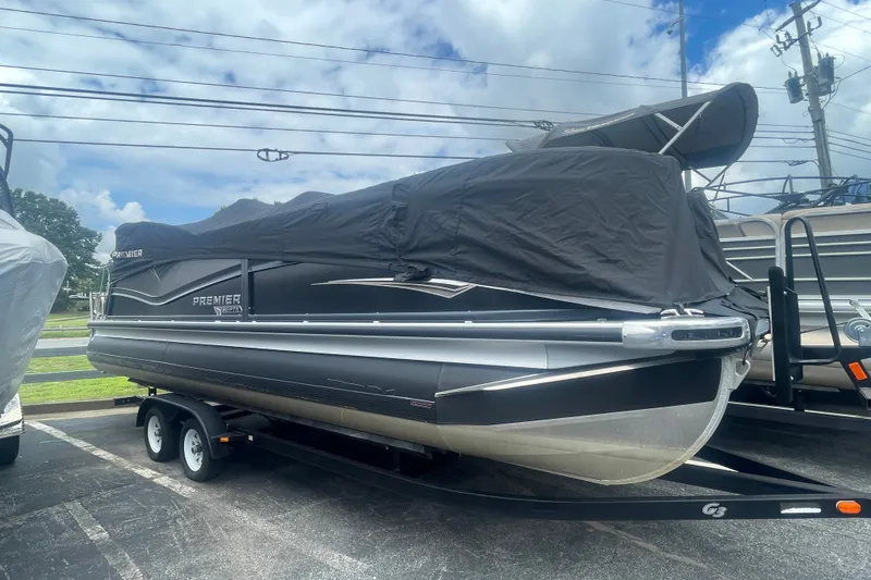 Slide: The Image of 2023 Premier SOLARIS 230 RL PTX pontoon boat covered, parked on a trailer. - 26