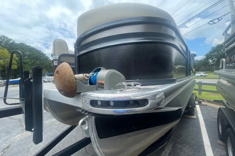 Slide: The Image of 2023 Premier SOLARIS 230 RL PTX pontoon boat front view in parking lot. - 4