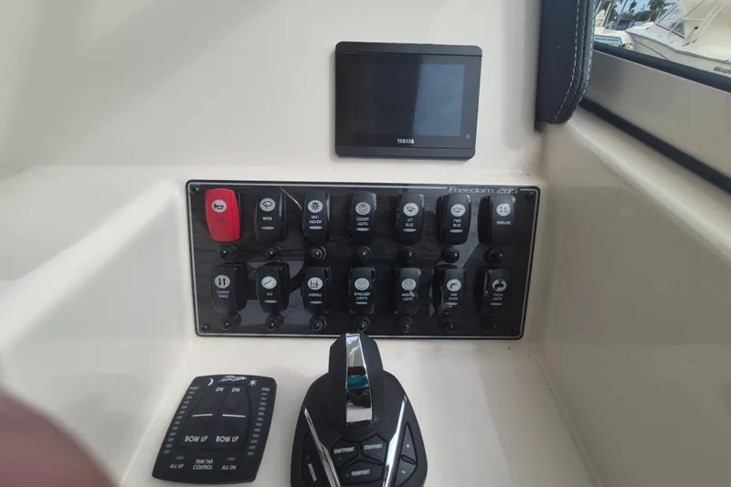 Slide: The Image of Control panel of 2027 Grady-White Freedom 285 boat with switches and display. - 10