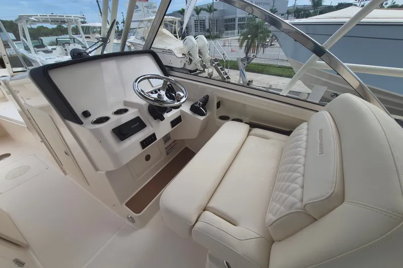 Slide: The Image of 2027 Grady-White Freedom 285 boat interior with steering wheel and seating. - 8
