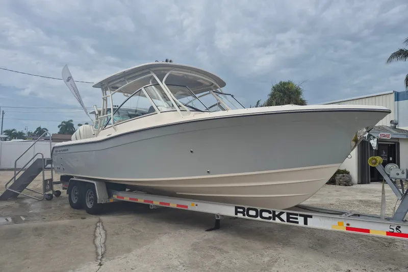 The Image of 2027 Grady-White Freedom 285 boat on trailer, parked outdoors under cloudy sky. - 0