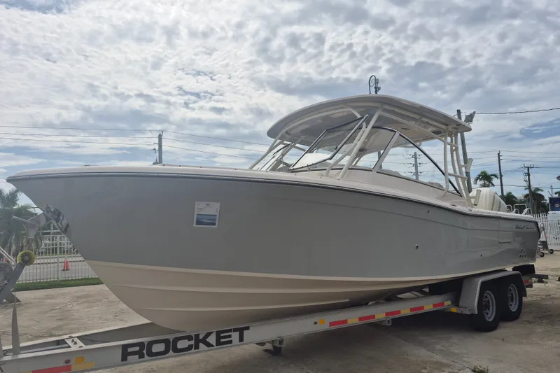 Slide: The Image of 2027 Grady-White Freedom 285 boat on trailer under cloudy sky. - 1