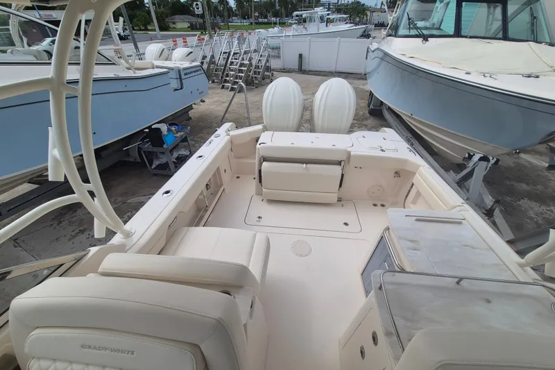 Slide: The Image of 2027 Grady-White Freedom 285 boat interior with seating and dual engines, docked outdoors. - 21