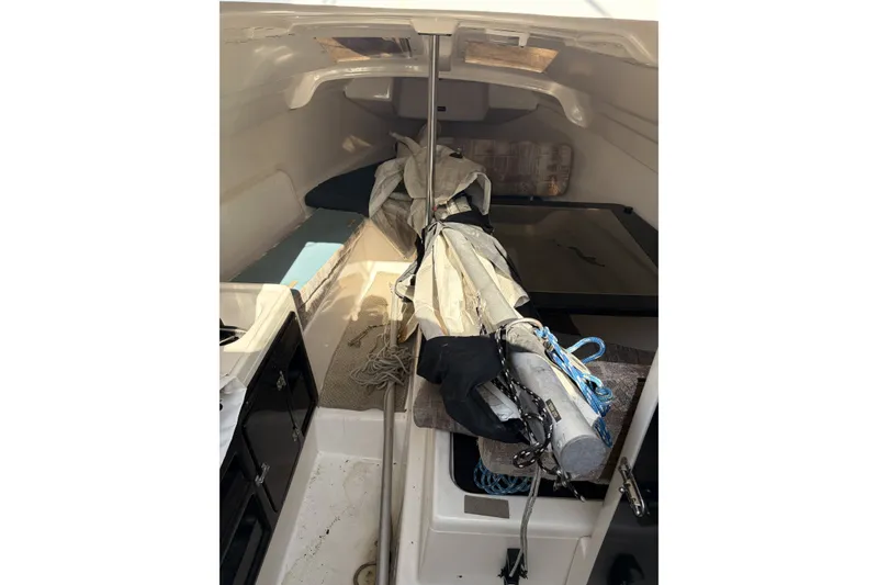 Slide: The Image of Interior of a 2000 MacGregor 26X sailboat, showing cabin space and stored sail equipment. - 15