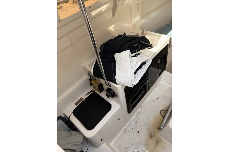 Slide: The Image of Interior of a 2000 MacGregor 26X sailboat with storage compartments and folded sails. - 16