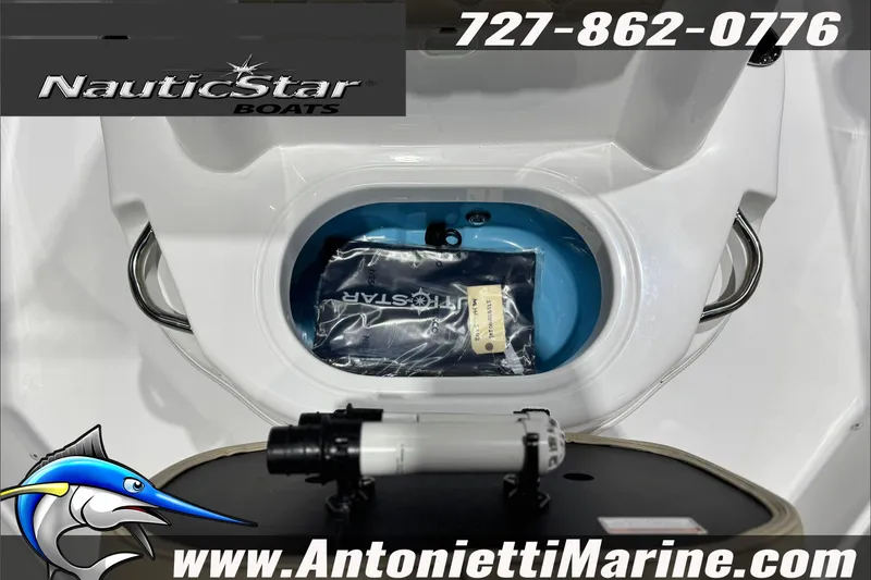Slide: The Image of 2025 NauticStar 194 Bay boat interior with storage compartment, contact info, and logo. - 13