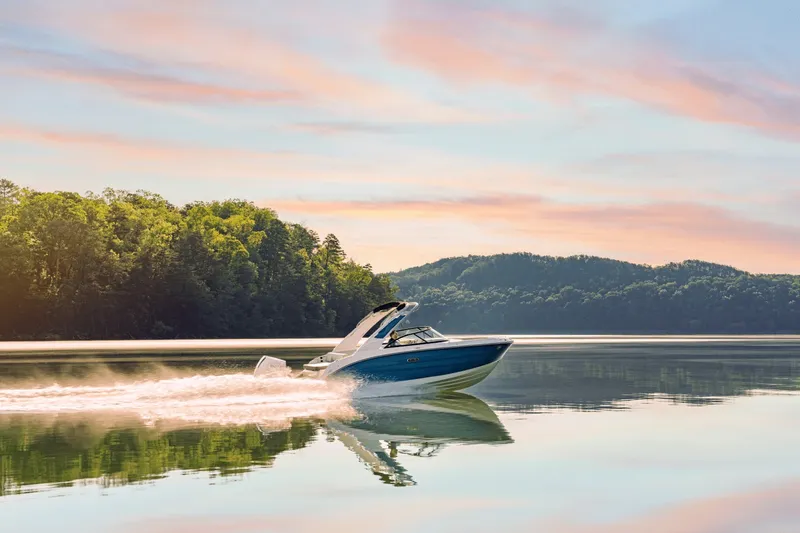 Slide: The Image of The 2027 Sea Ray SDX 230 Outboard glides over calm water at sunset. - 4