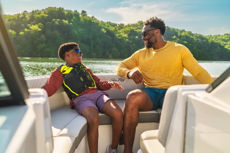 Slide: The Image of Father and son enjoying a boat ride on a Sea Ray SDX 230 Outboard. - 11