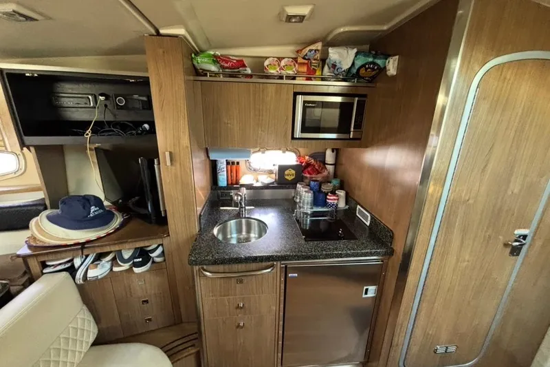 Slide: The Image of 2011 CHAPPARELL Signature 330 interior with kitchenette, microwave, and storage shelves. - 24