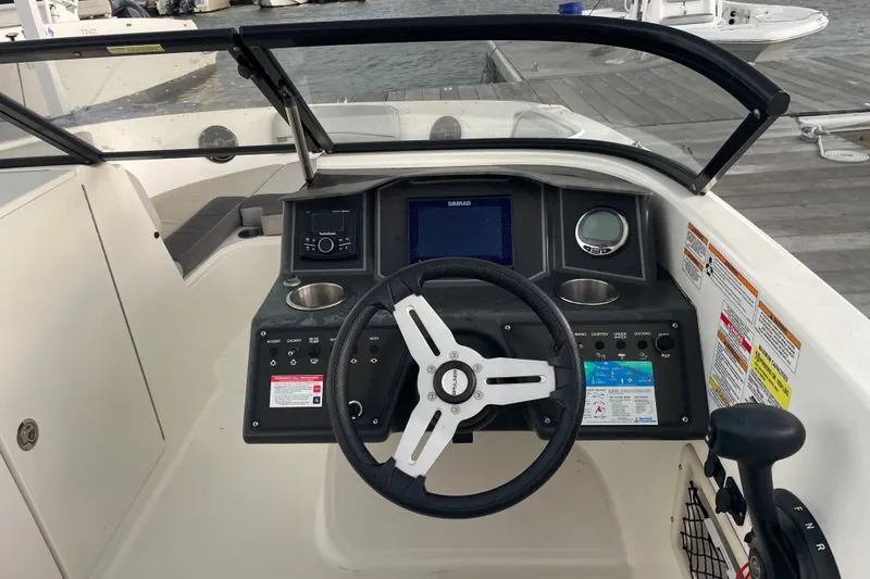 Slide: The Image of 2023 Bayliner VR6 Bowrider OB dashboard with steering wheel and control panel. - 8