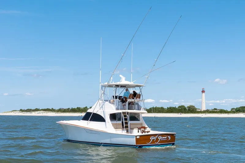 Slide: The Image of 2021 Viking 46 Billfish yacht on water near a lighthouse, clear blue sky. - 27