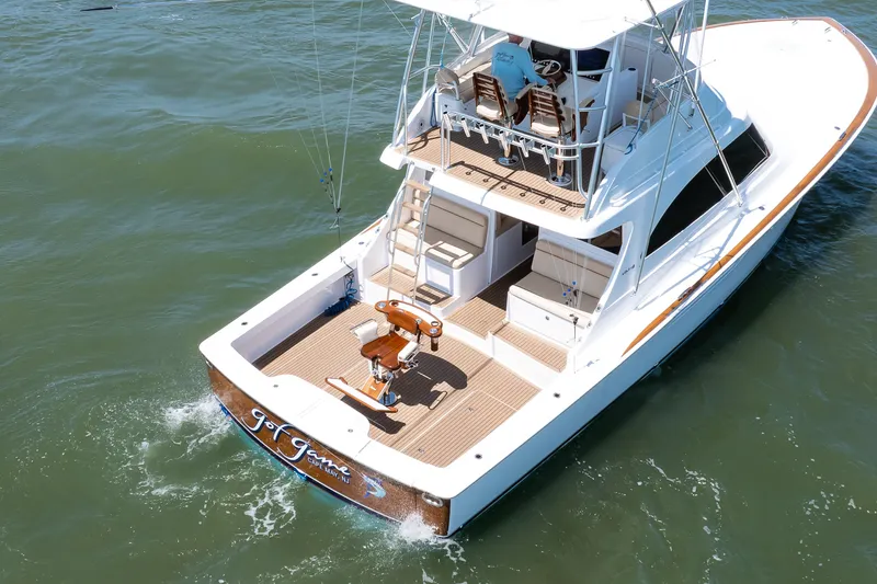 Slide: The Image of 2021 Viking 46 Billfish yacht cruising on open water, showcasing spacious deck and seating. - 14
