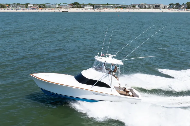 Slide: The Image of 2021 Viking 46 Billfish yacht cruising on ocean near a sandy beach. - 28