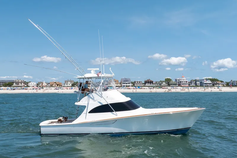 Slide: The Image of 2021 Viking 46 Billfish yacht cruising near a sunny beach with clear skies. - 30