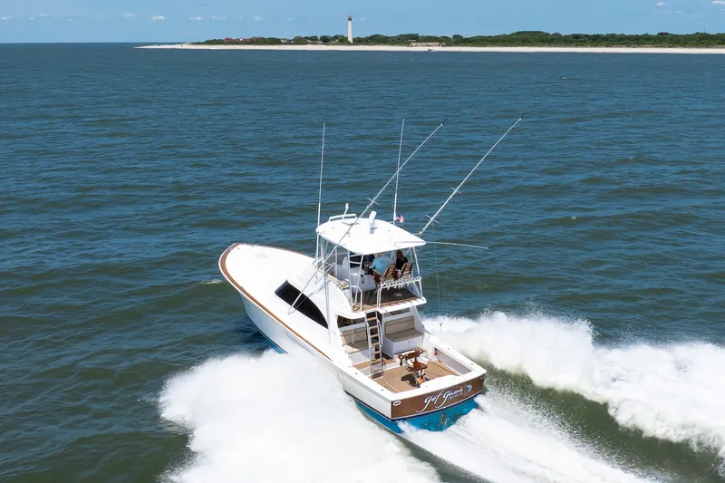 Slide: The Image of 2021 Viking 46 Billfish cruising on open water near a distant lighthouse. - 29