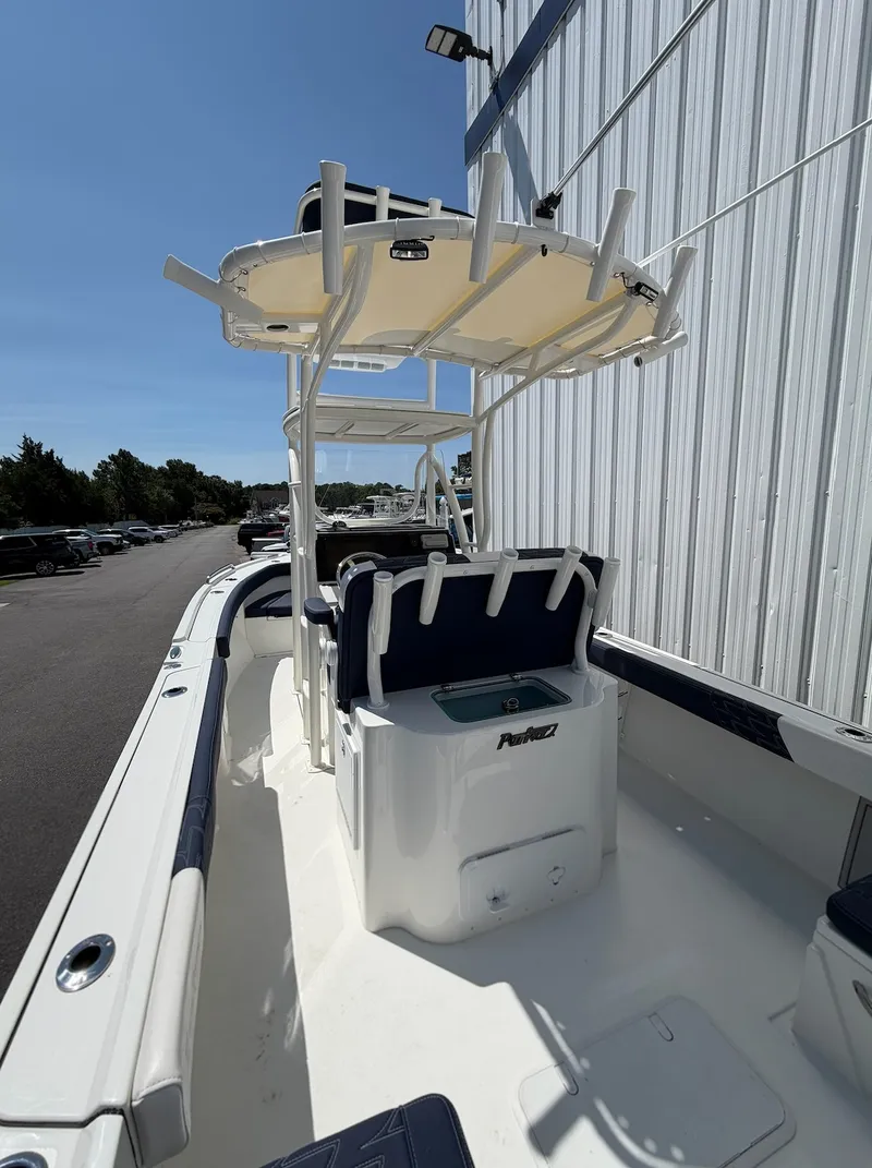 Slide: The Image of The image shows a 2026 Parker 210 Coastal boat. It features a T-top and a central console. - 15