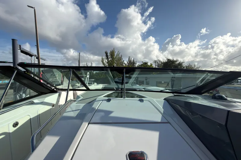 Slide: The Image of 2019 Cruisers Yachts 338 Outboard boat with sleek design under a partly cloudy sky. - 22