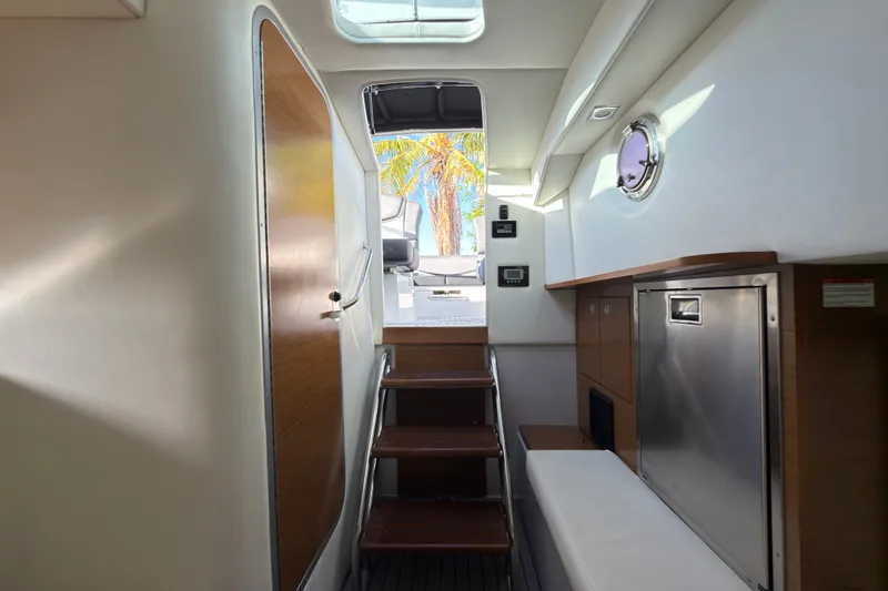 Slide: The Image of Interior of 2019 Cruisers Yachts 338 Outboard, featuring stairs and modern cabinetry. - 14