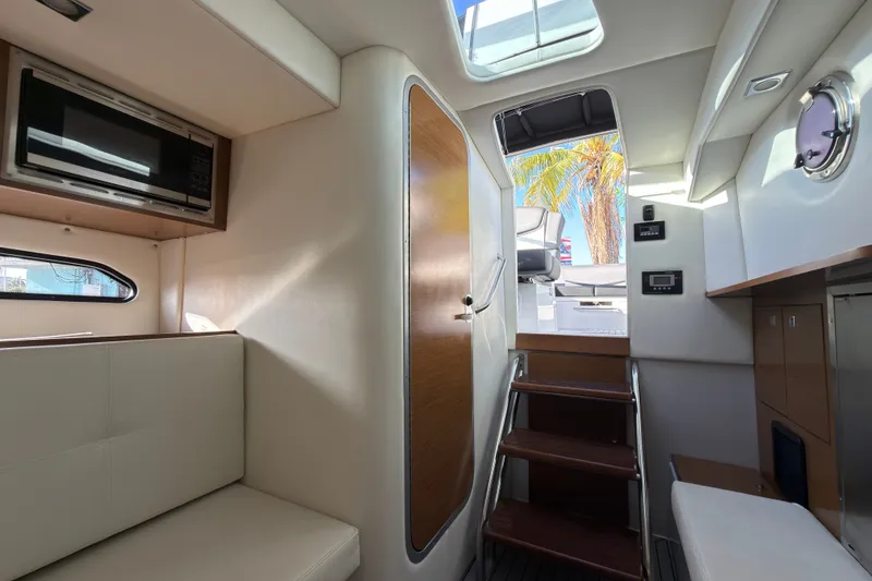 Slide: The Image of Interior of 2019 Cruisers Yachts 338 Outboard, featuring stairs, seating, and a microwave. - 15
