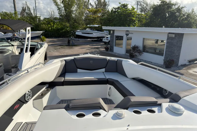 Slide: The Image of 2019 Cruisers Yachts 338 Outboard with spacious seating, docked near a marina building. - 23