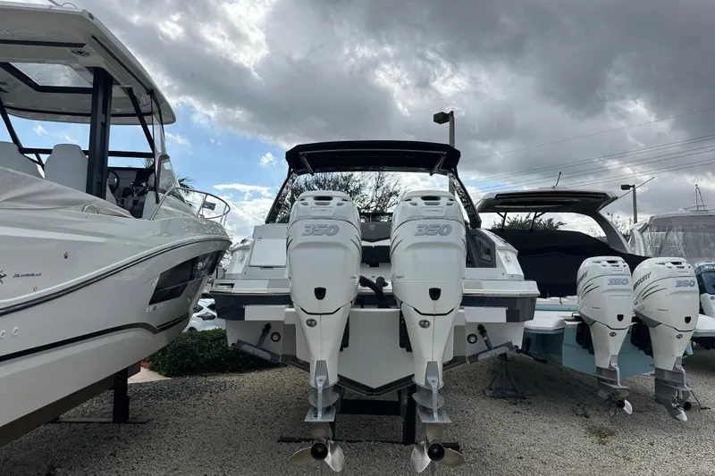 Slide: The Image of 2019 Cruisers Yachts 338 Outboard with twin engines, displayed outdoors under cloudy skies. - 37