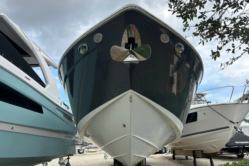Slide: The Image of 2019 Cruisers Yachts 338 Outboard, docked among other boats, under a cloudy sky. - 32