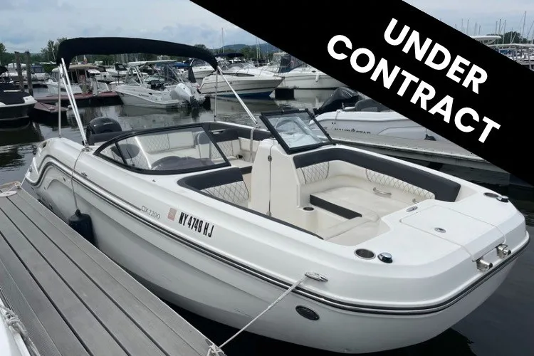 The Image of 2023 Bayliner DX 2200 boat docked, labeled "Under Contract" at marina. - 1