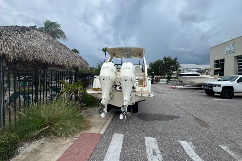 Slide: The Image of 2022 Scout 277 Dorado boat with dual engines parked near a thatched-roof structure. - 10