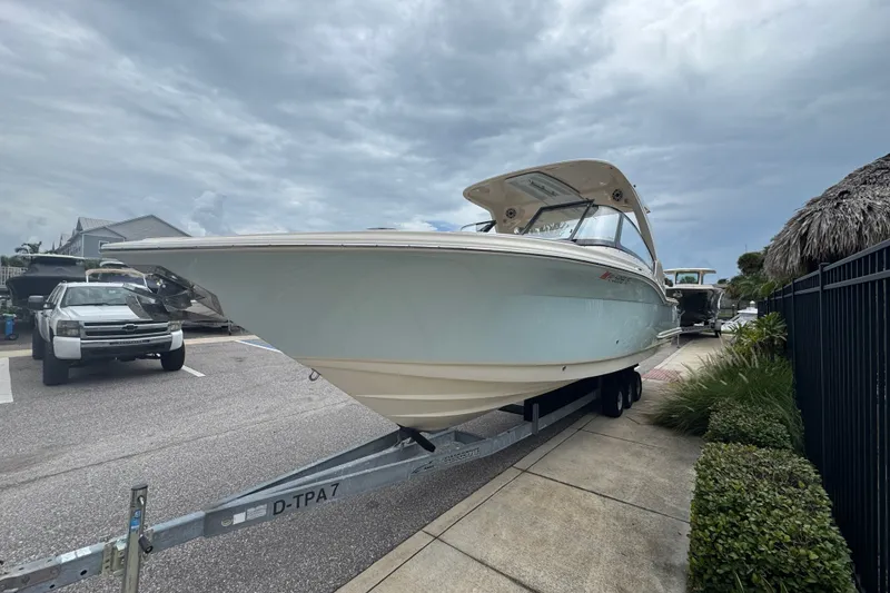 Slide: The Image of 2022 Scout 277 Dorado boat on trailer, parked outdoors under cloudy sky. - 6