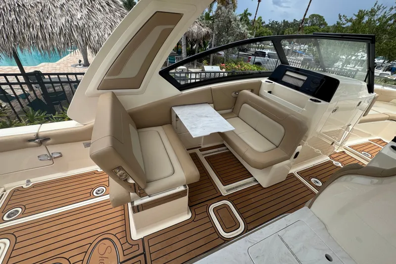 Slide: The Image of 2022 Scout 277 Dorado boat interior with tan seating and wood flooring. - 19
