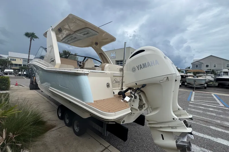 Slide: The Image of 2022 Scout 277 Dorado boat with Yamaha engine, parked outdoors under cloudy sky. - 8