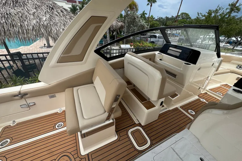 Slide: The Image of 2022 Scout 277 Dorado boat interior with beige seating and wood-patterned flooring. - 18