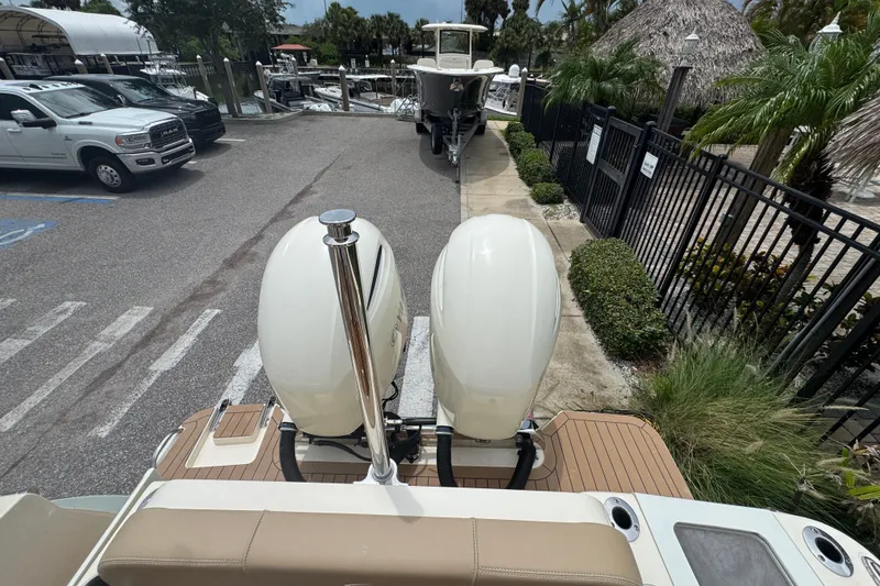 Slide: The Image of 2022 Scout 277 Dorado boat with dual engines at a marina parking area. - 31